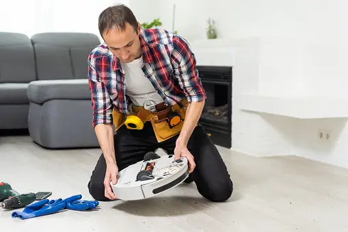 A man is seen maintaining the Shark robot vacuum